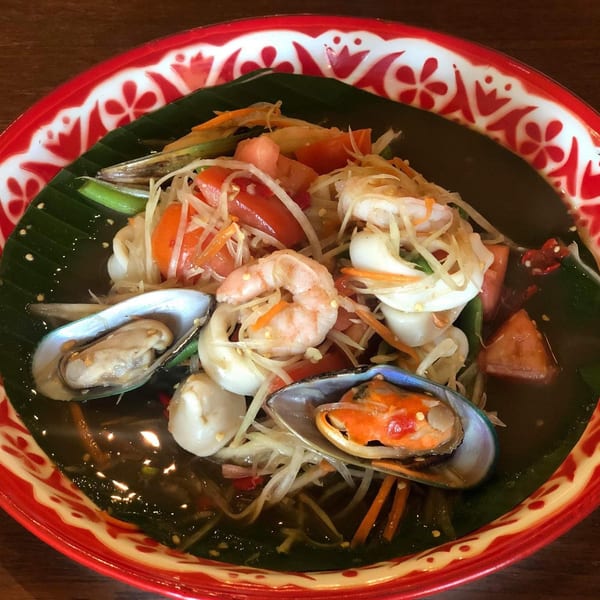 Tamarind Thai Cuisine's papaya salad with shrimp, squid, mussels, and vegetables in a red patterned bowl.
